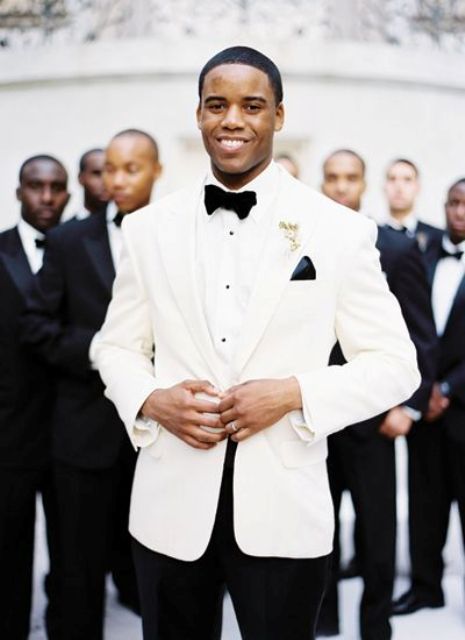 Picture Of dapper groom in a white dinner jacket looks w