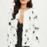 This white faux fur coat features black leopard spots, open front .
