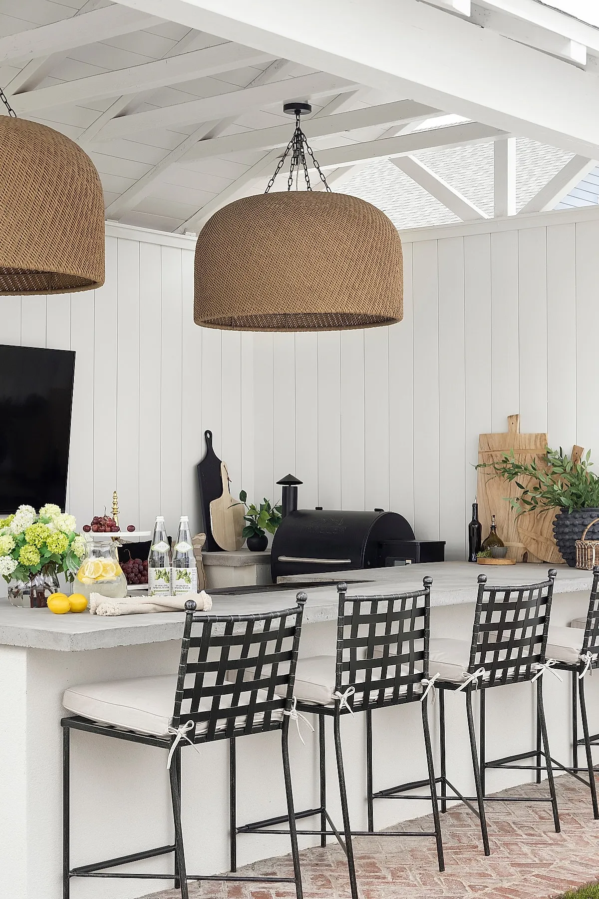 Woven basket pendant lights above a kitchen island with bar stools.