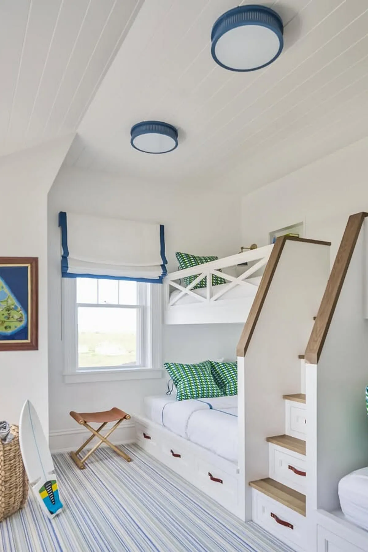 Nautical-themed room with built-in bunk beds, blue accents, under-bed storage drawers, and wooden steps for access.