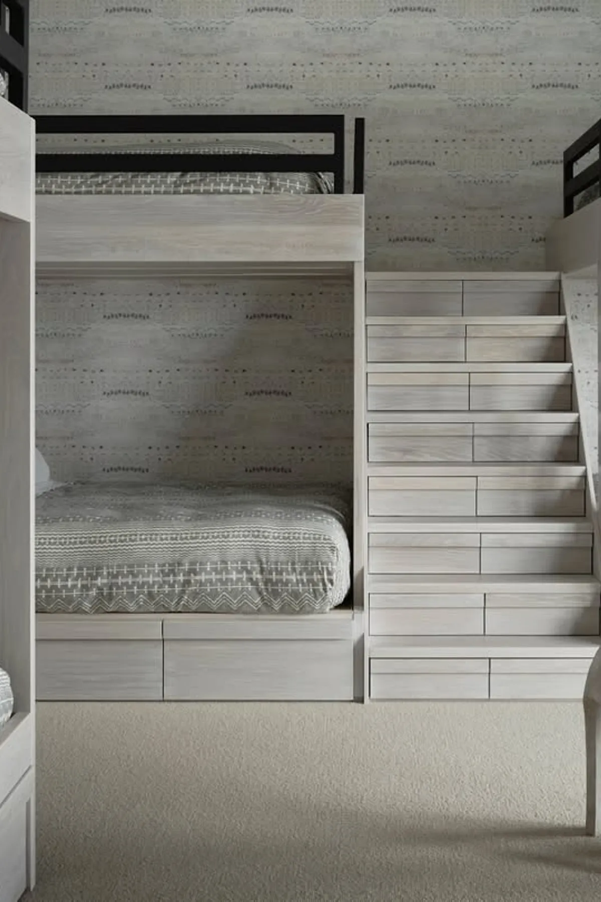 Large bunk beds with wide staircase for adult use in a neutral-toned room.