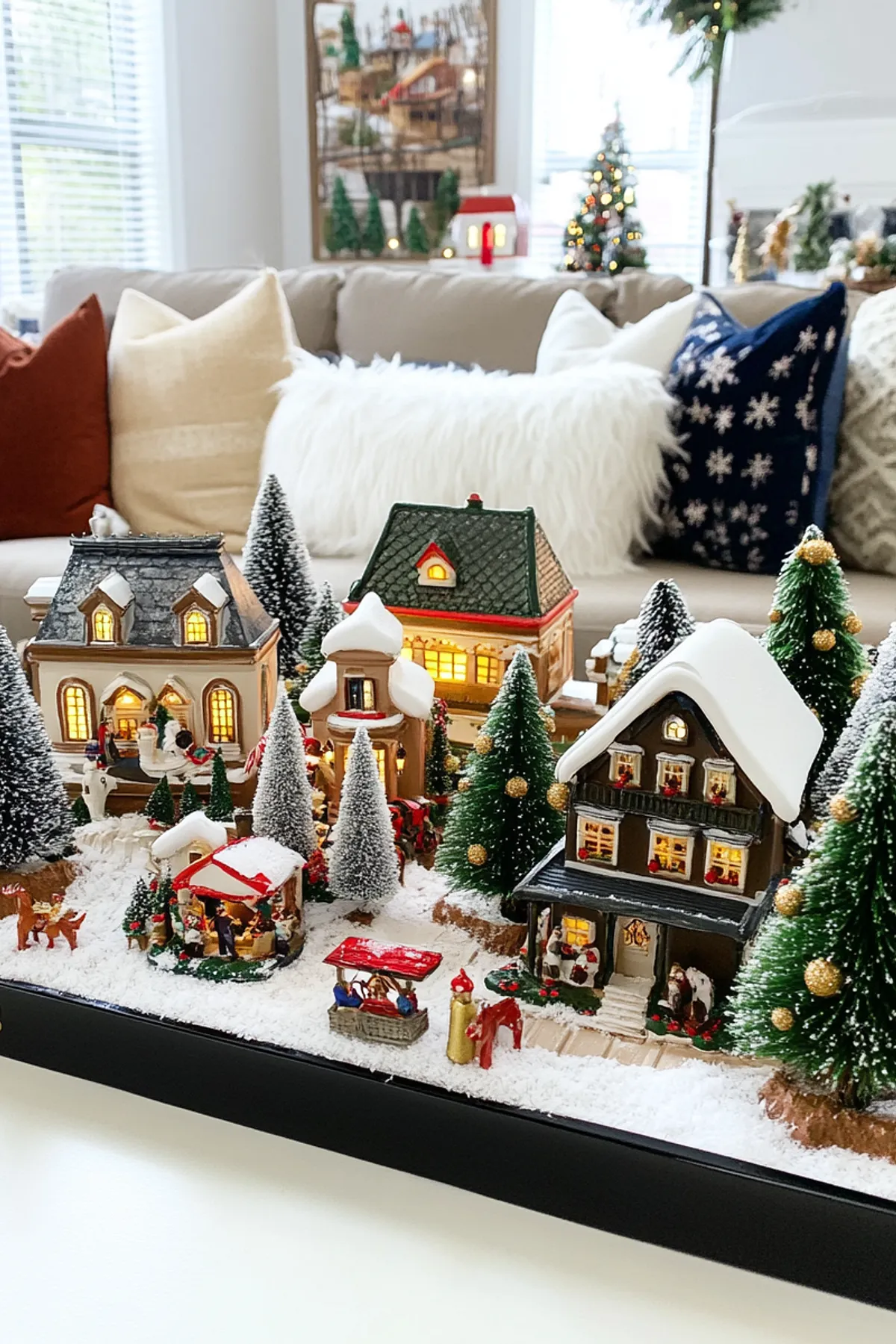 Cozy living room featuring a colorful miniature village on a black tray, alongside a comfortable sofa and festive decorations.