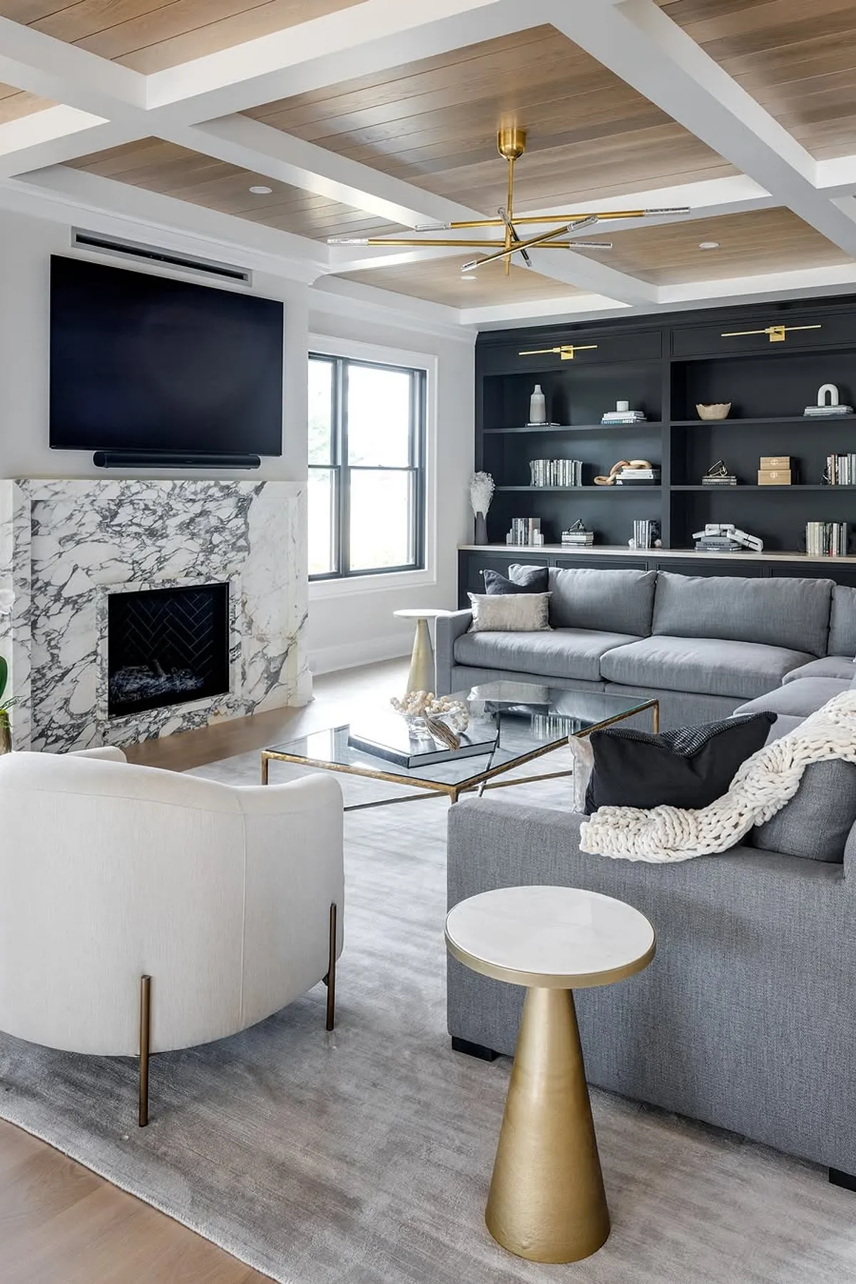 Living room featuring fireplace with marble surround, tv, box beam ceiling and sectional sofa