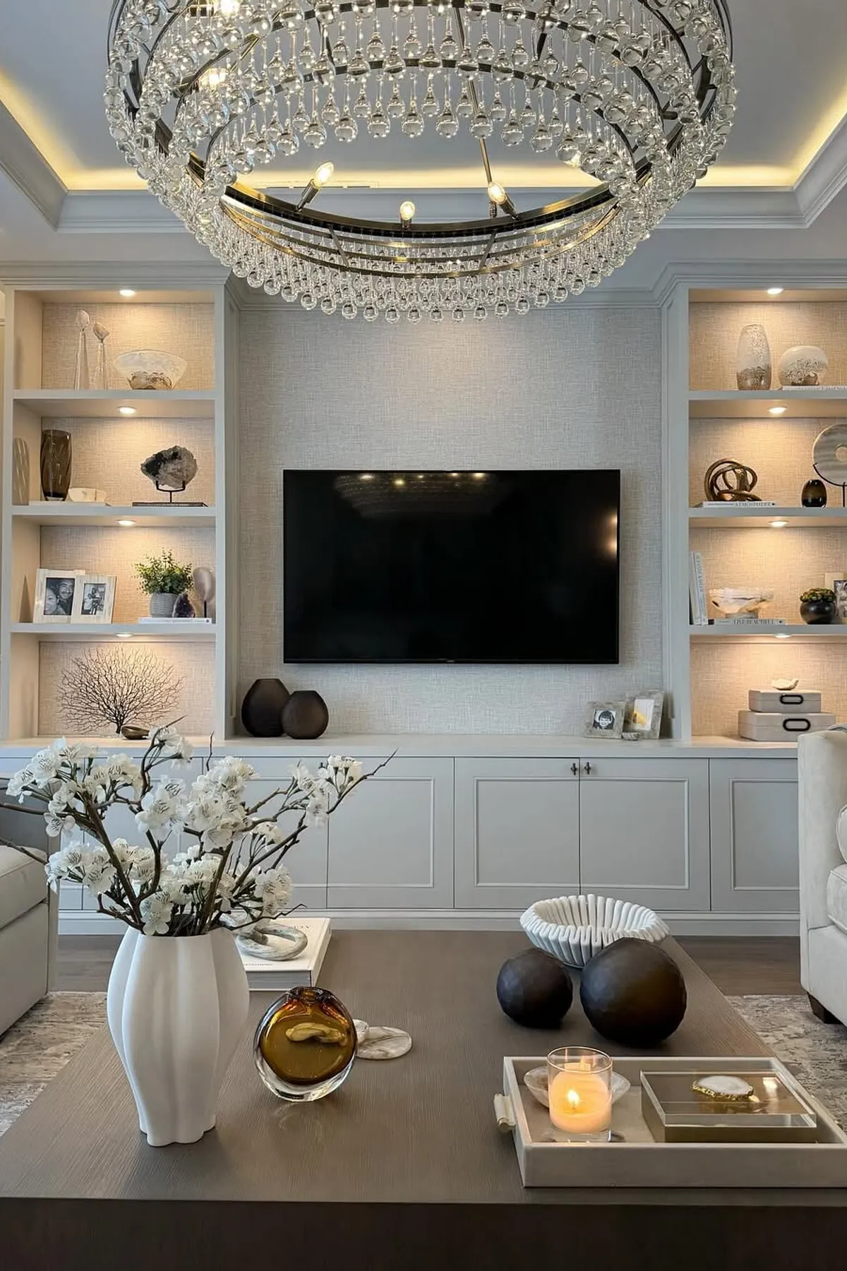 living room showcasing chandelier and TV