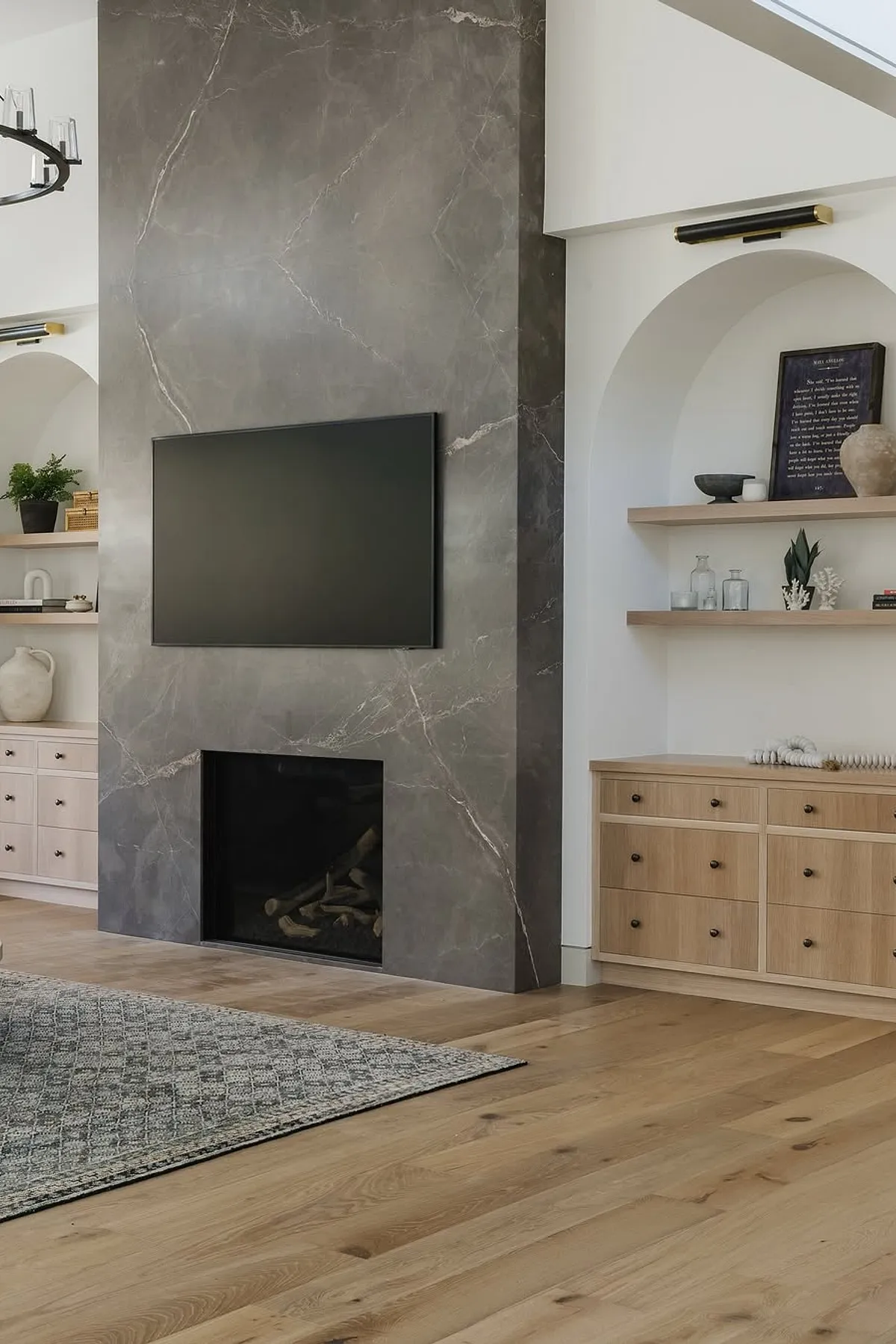 living room showcasing beautiful marble fireplace wall with tv and wide plank oak floors