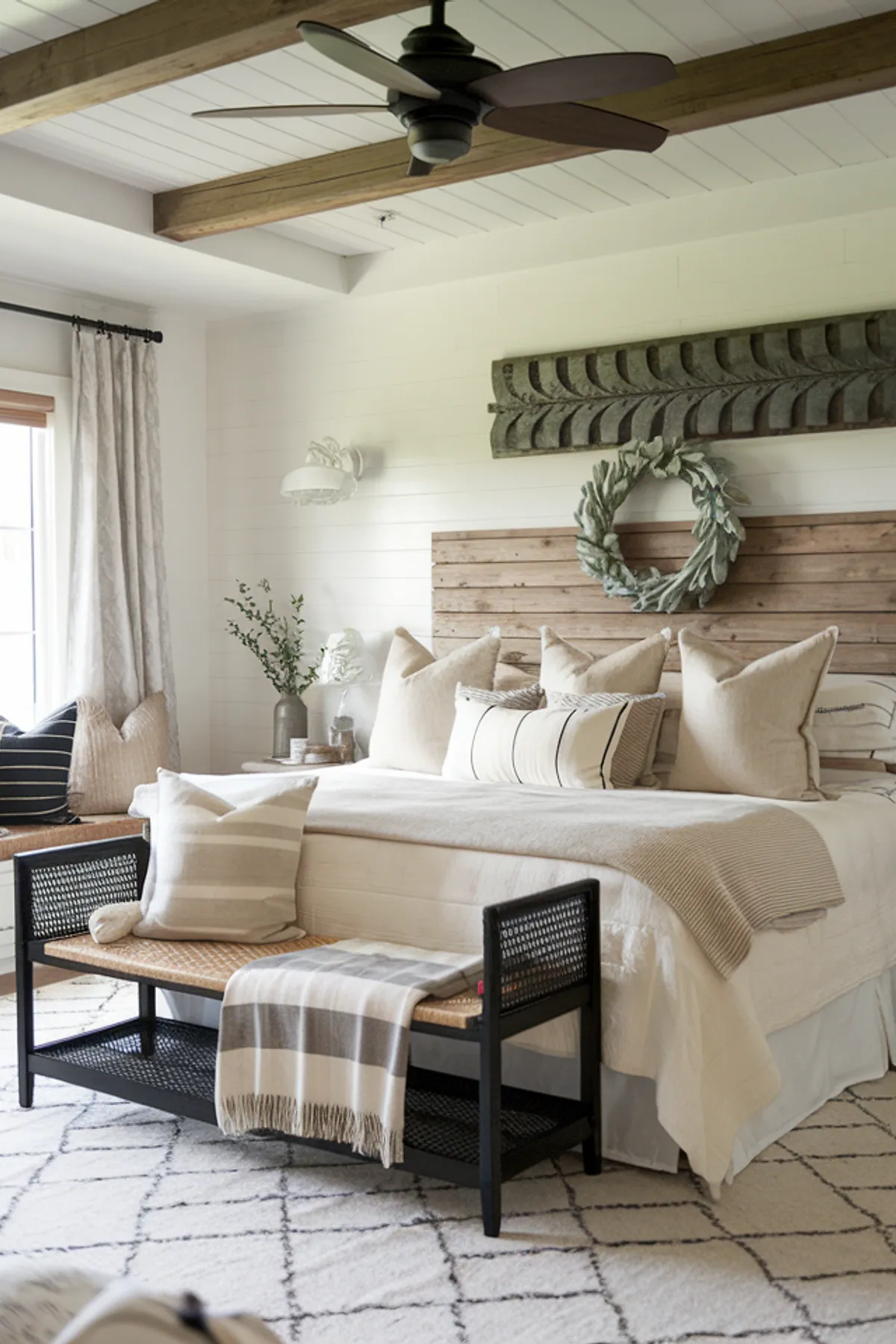 Rustic bedroom with wooden beams, black bench, and a white rug with black patterns.