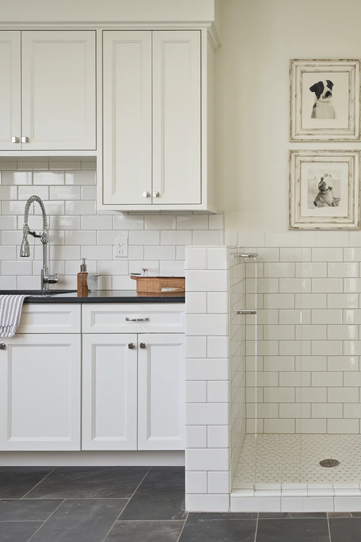 A modern laundry room featuring an integrated shower and sleek white cabinetry.