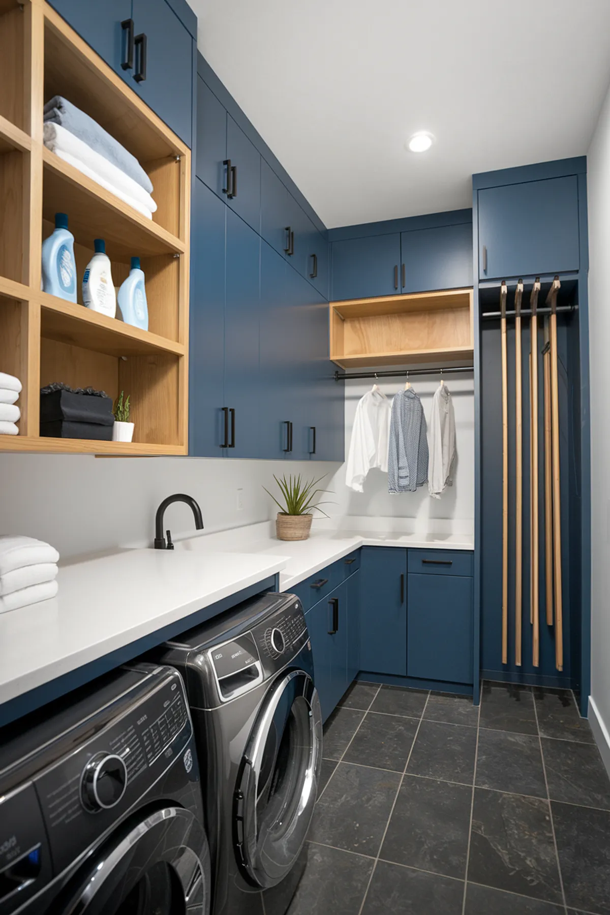 A functional laundry room featuring blue cabinets, open shelving, and a hanging space.