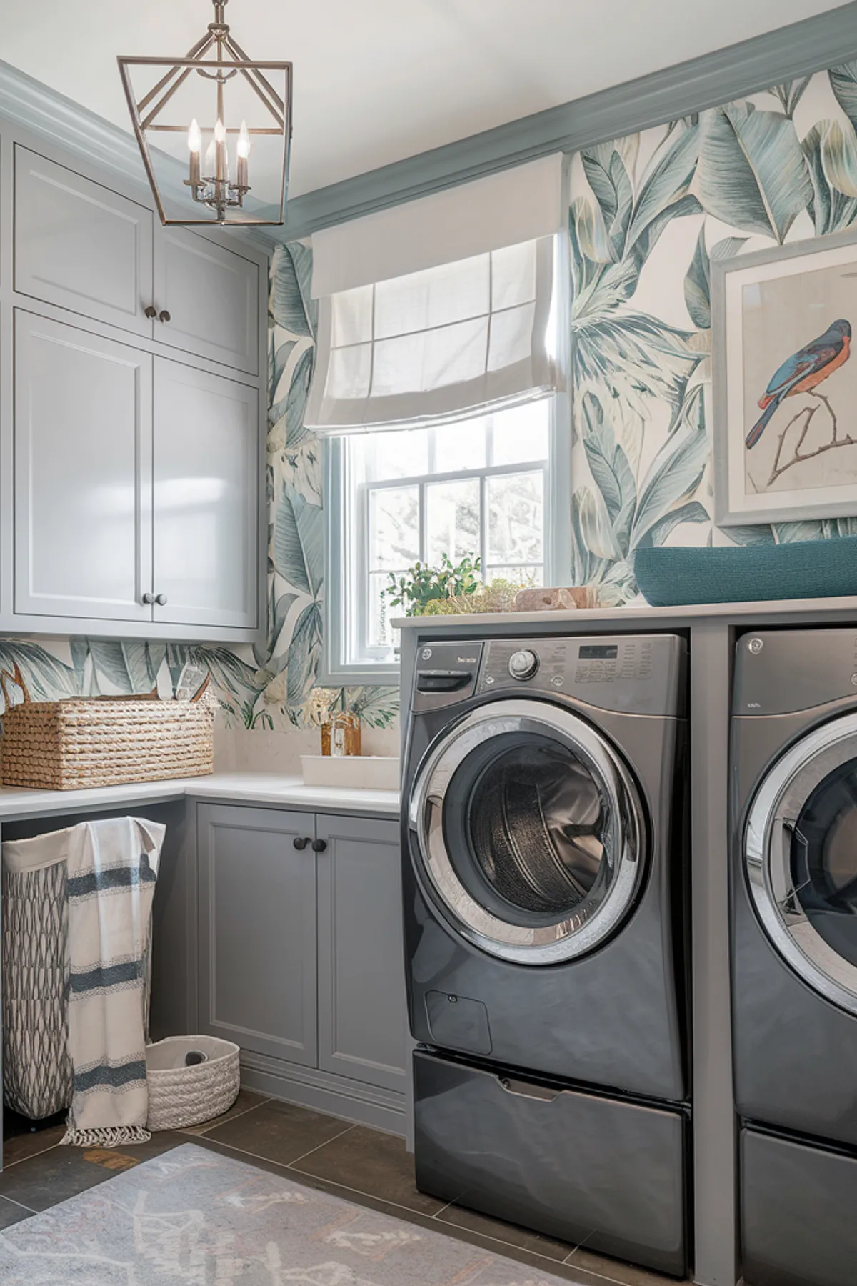 A tropical-themed laundry room featuring palm leaf wallpaper and gray cabinetry.