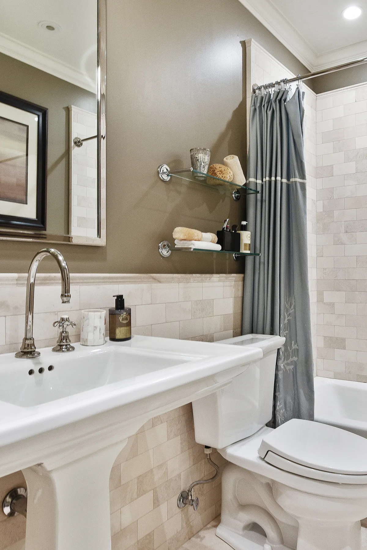 A classic bathroom featuring earthy tones, elegant fixtures, and soft curtains.