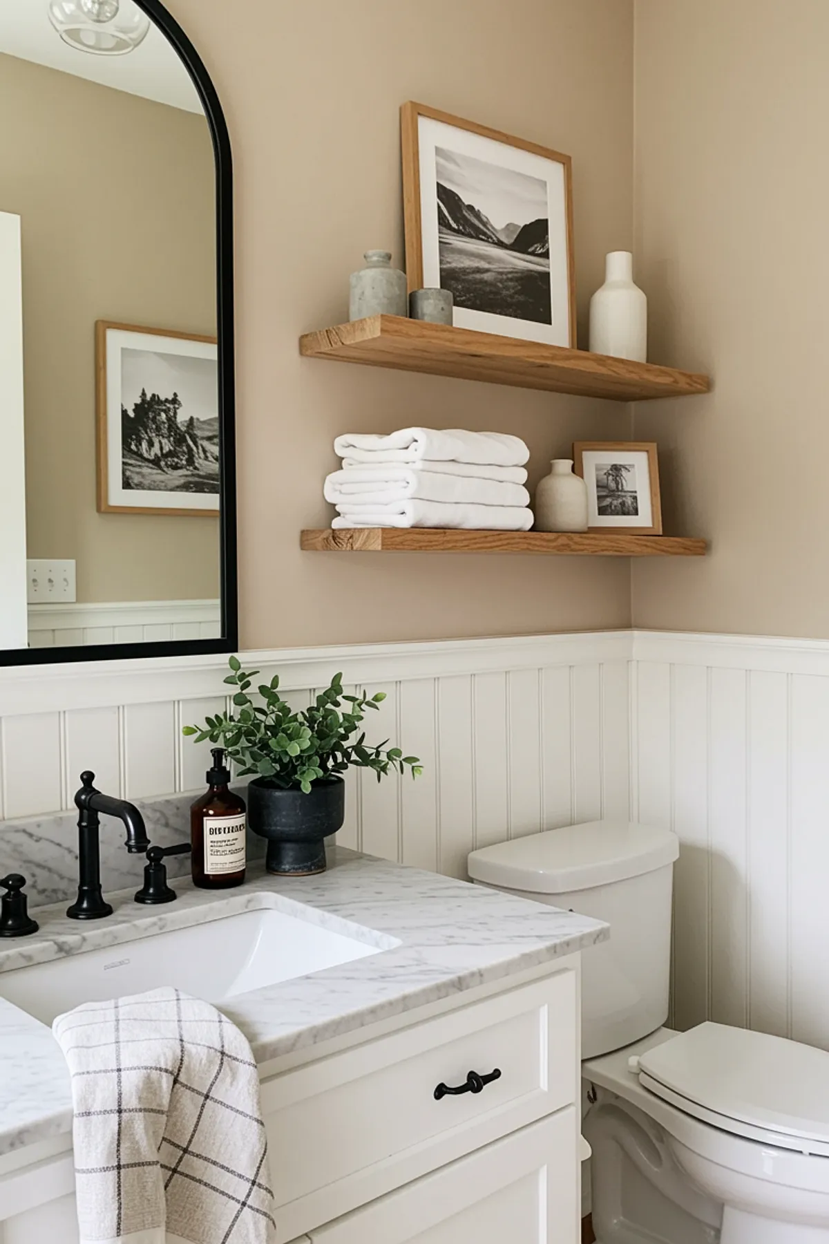 A neutral bathroom featuring marble countertop, wooden shelves, and elegant decor.