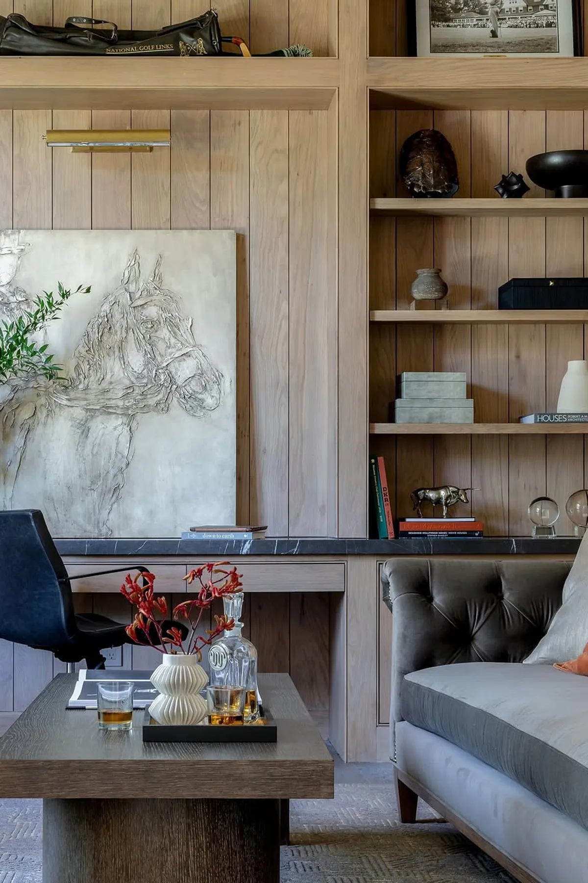 Modern living room featuring wooden shelves, contemporary artwork, decorative objects, and a chic coffee table.