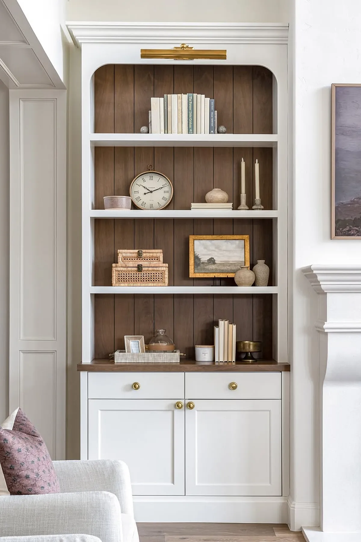 Elegant shelf design featuring white shelves, wooden backdrop, decorative objects, and storage baskets.