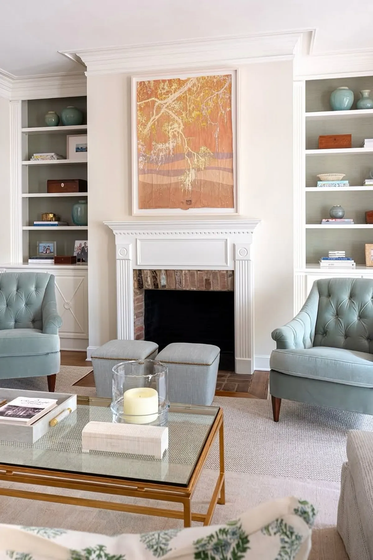Modern living room featuring mint green chairs, stylish shelving, colorful artwork, and a cozy coffee table.