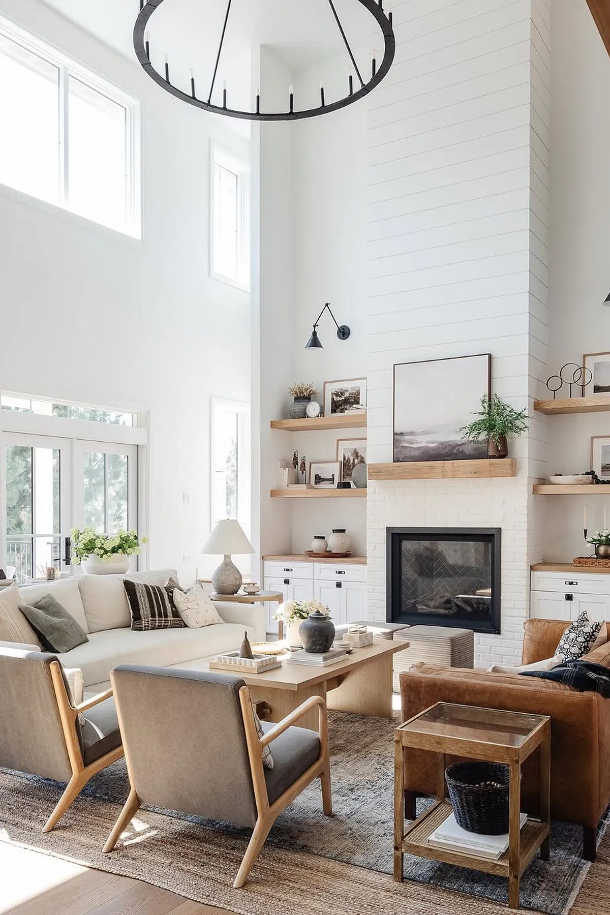 Modern living room featuring white walls, natural wood shelves, stylish furniture, and decorative accents.