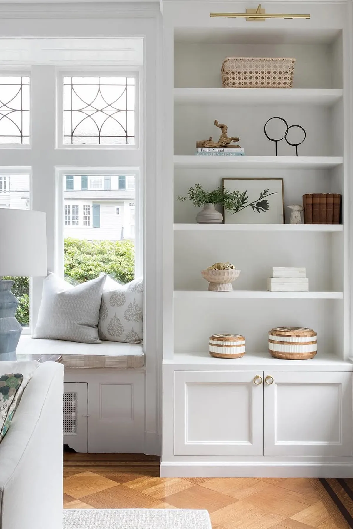Modern shelf design featuring white shelving, decorative basket, books, greenery, and framed artwork.