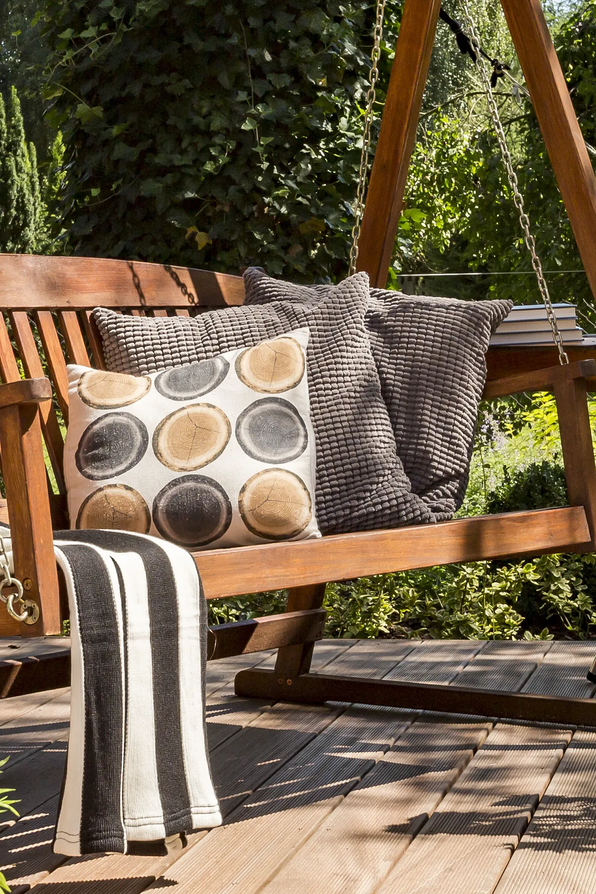 A wood swing with rich textures and grounding hues creates a warm and stylish retreat.