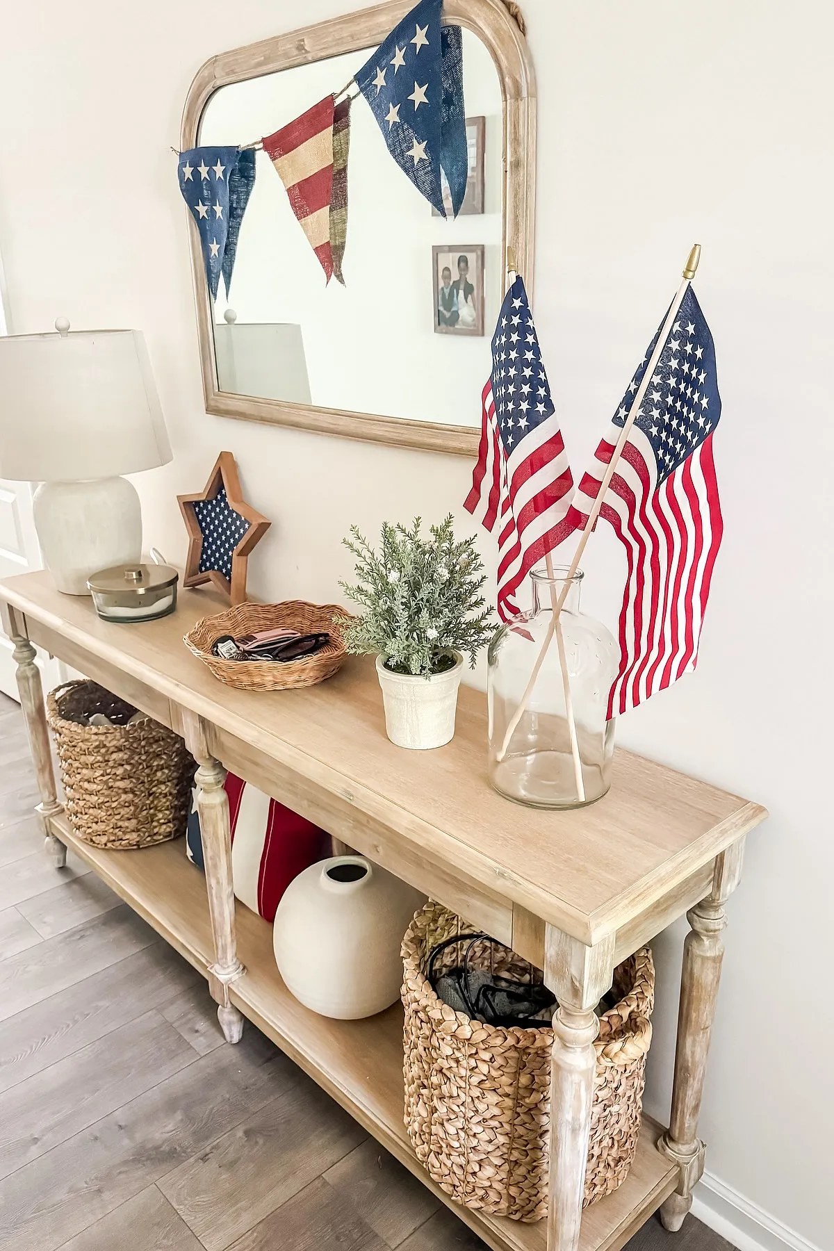 An entryway featuring American flags, a mirrored wall, and rustic wooden furniture with woven baskets.