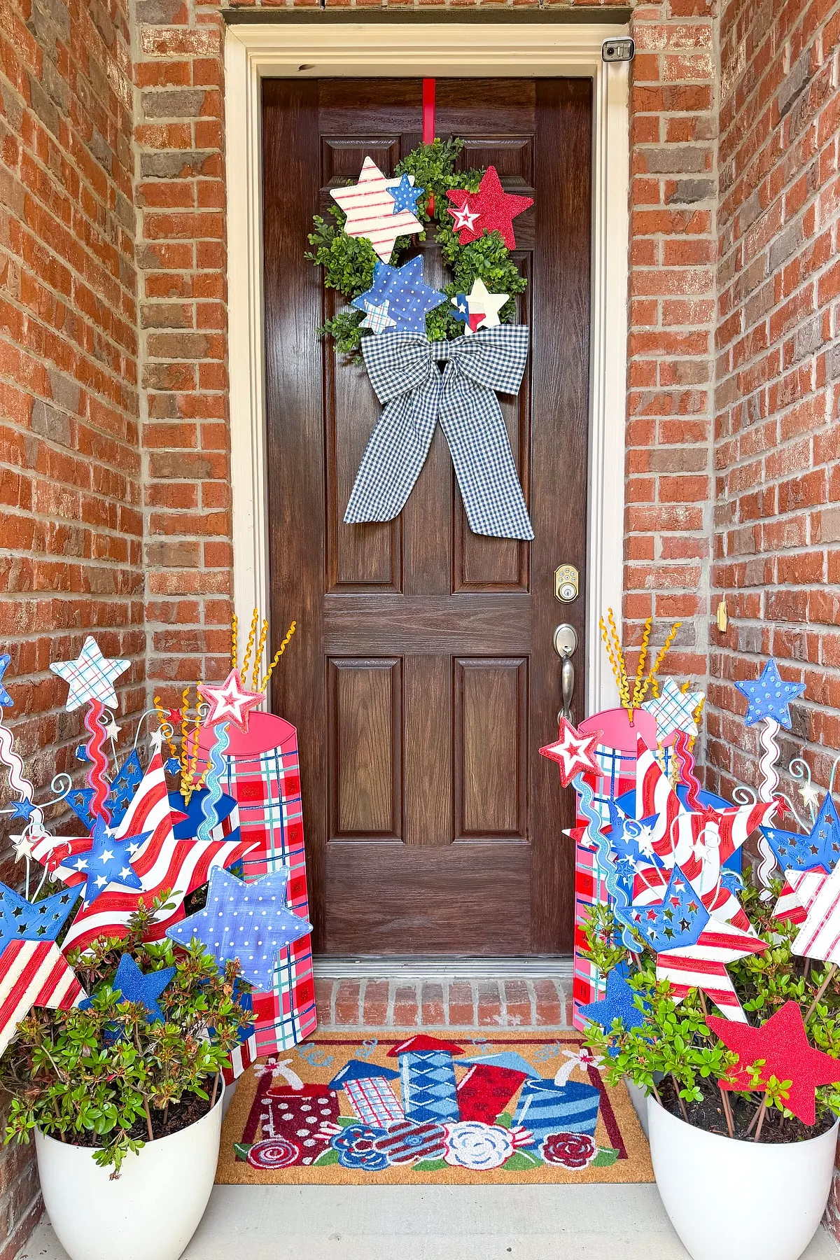 A festive 4th of July entryway featuring a star-themed wreath, colorful decorations, and a patterned welcome mat.