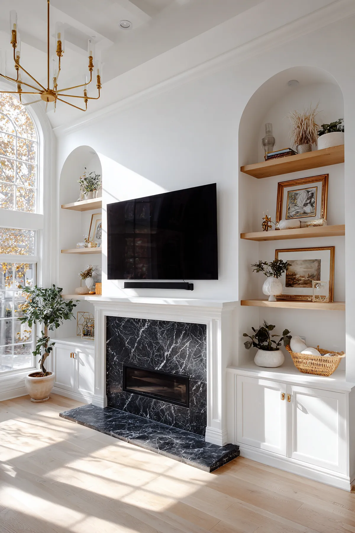 Elegant modern TV wall with black marble fireplace, white cabinetry, open shelving, and decorative accents.