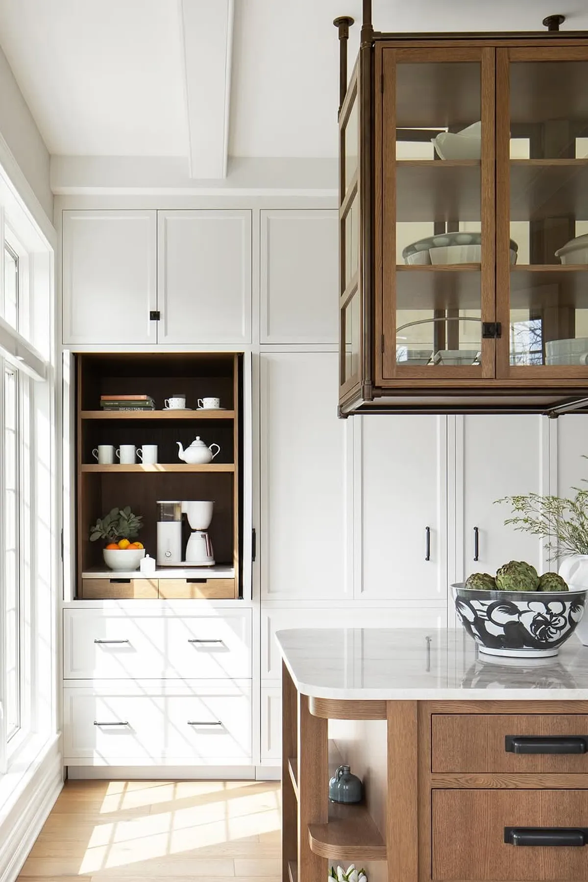 White cabinet with an open section featuring wooden shelves and drawers, showcasing coffee essentials.