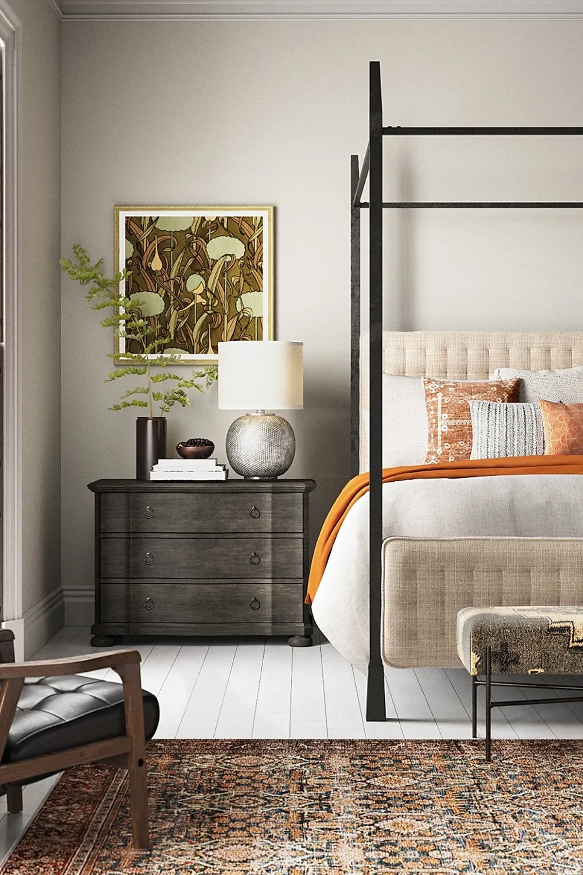 Bedroom with black metal canopy bed frame, beige upholstered headboard, orange and patterned pillows, dark wooden nightstand with lamp and plant, colorful patterned area rug on white floor