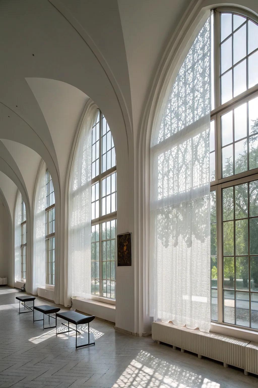 Modern minimalist space featuring sheer screens on arched windows.
