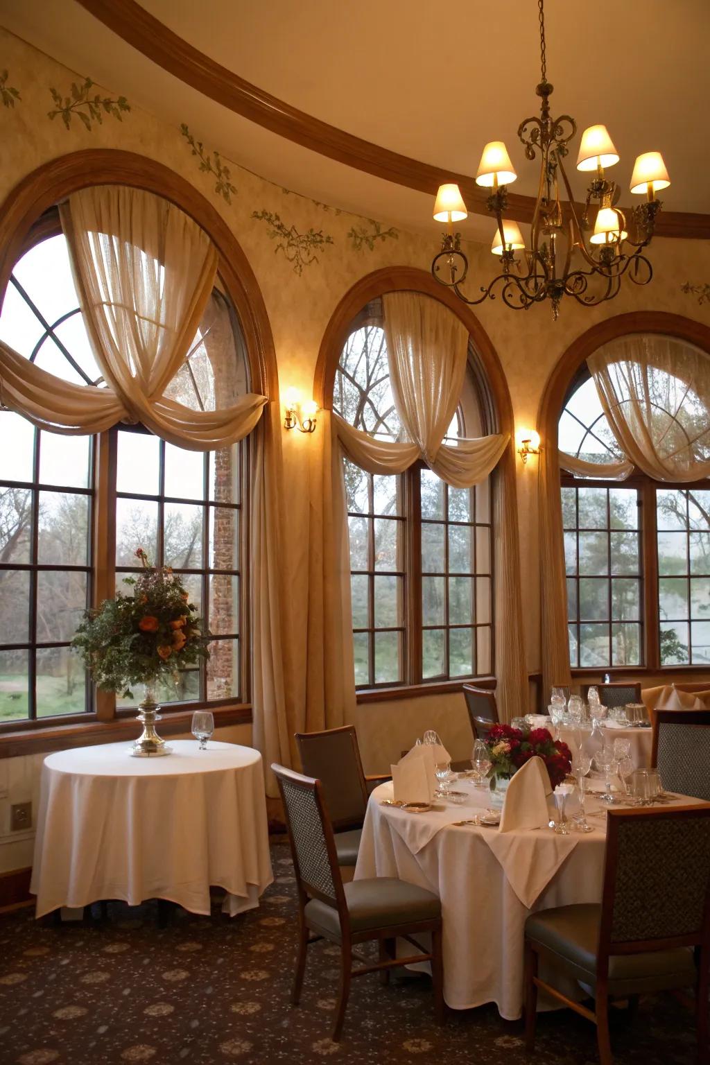 Romantic dining room featuring fabric loops on arched windows.