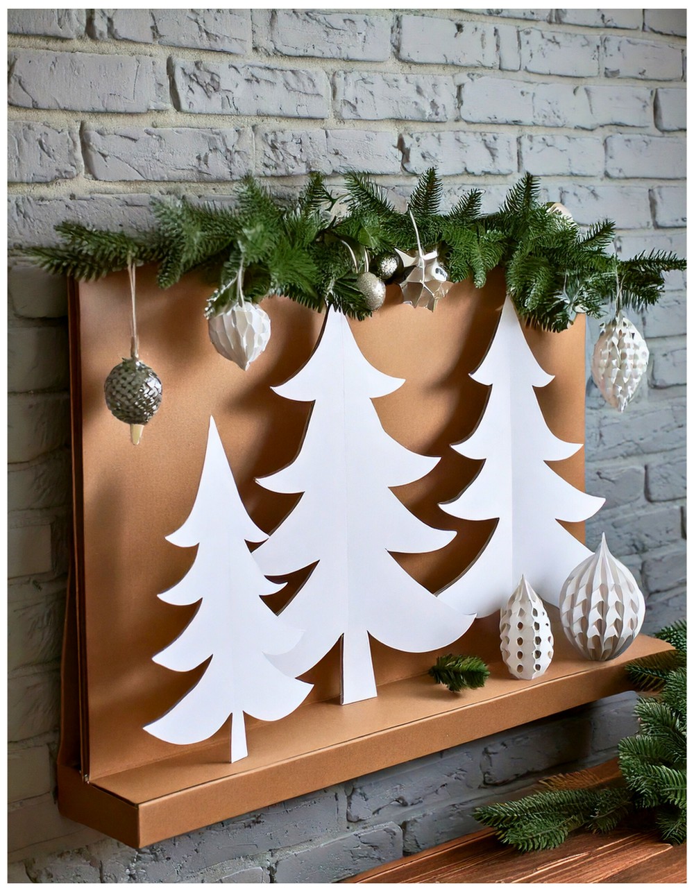 Cardboard Christmas tree cutouts painted white and layered for 3D effect