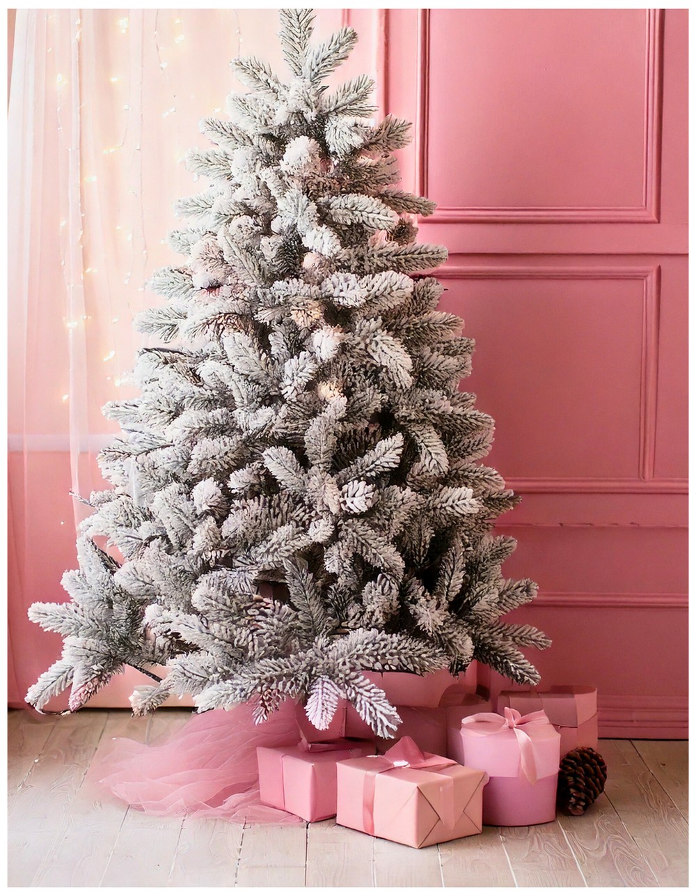 Pink and white Christmas tree with snow-dusted branches and frosted pinecones