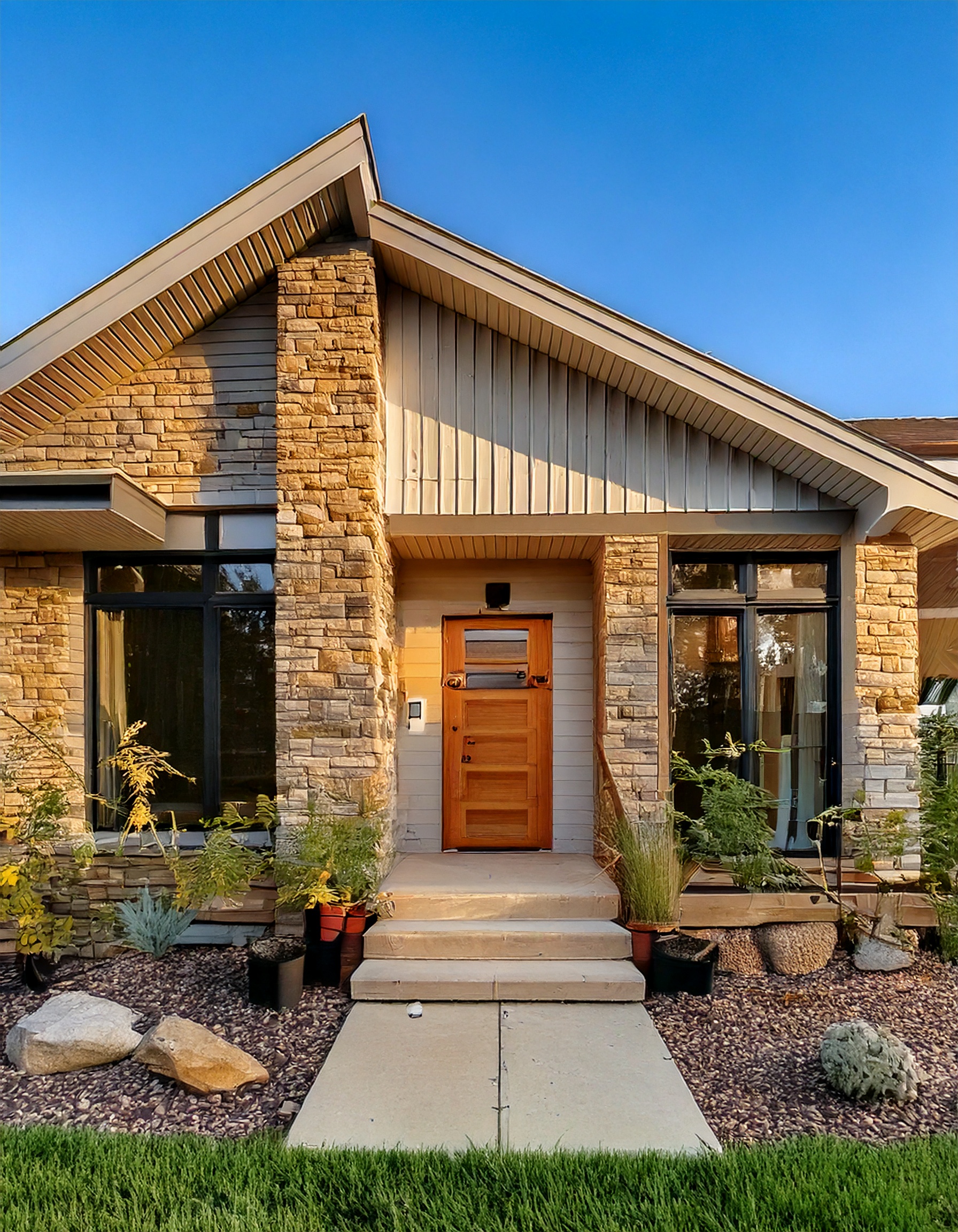 Modern ranch facade with black-framed windows and stone accents