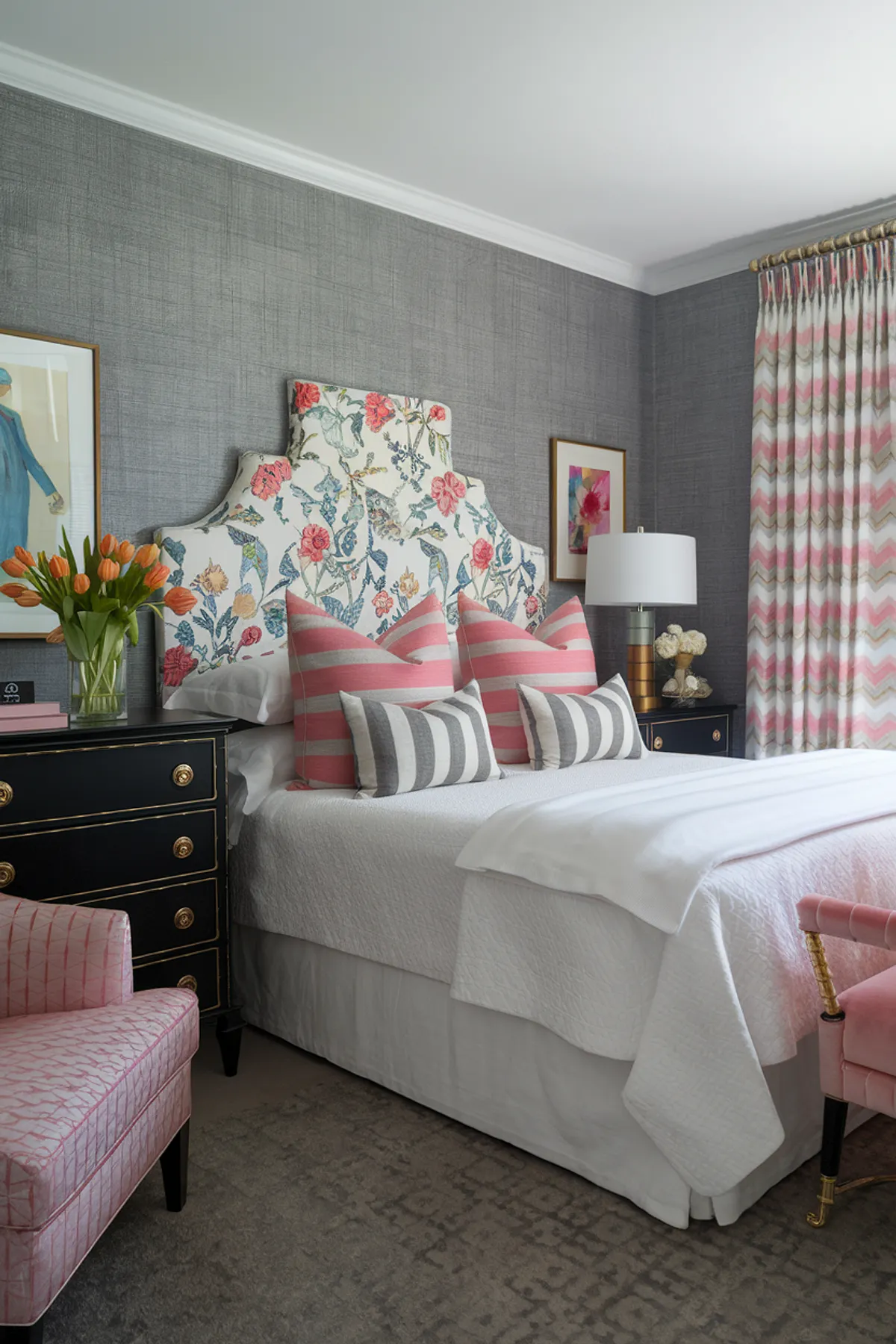 Bedroom with floral headboard, striped pillows, and pink accents including an armchair.