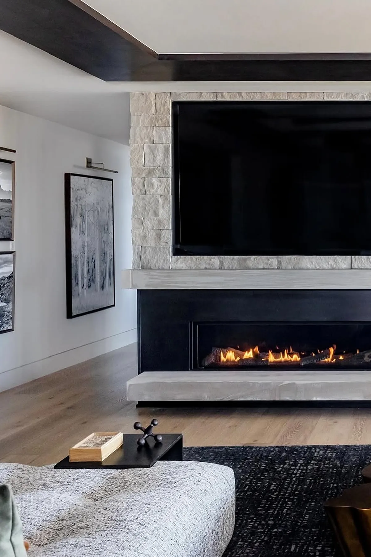 Modern living room with stone fireplace and TV above
